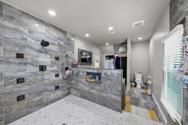 bathroom featuring toilet and a tile shower