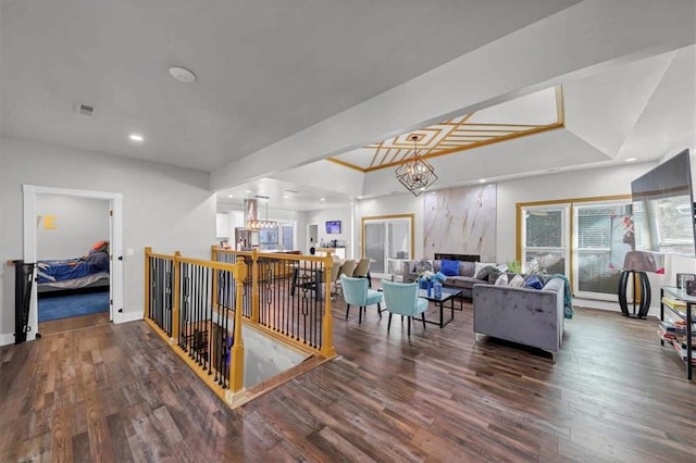 interior space with a raised ceiling, dark hardwood / wood-style flooring, and an inviting chandelier