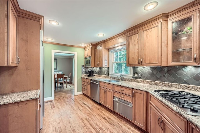 kitchen with a sink, stainless steel appliances, decorative backsplash, a warming drawer, and ornamental molding