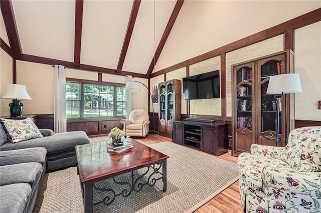 living room with light wood finished floors, high vaulted ceiling, and beam ceiling