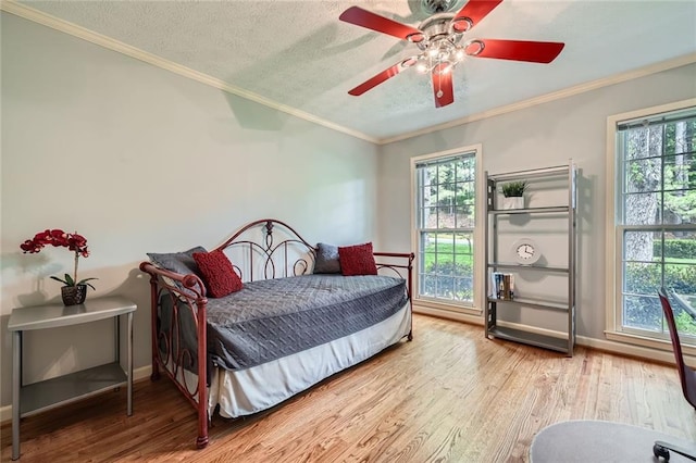 bedroom featuring ornamental molding, multiple windows, and wood finished floors
