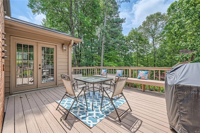 wooden terrace featuring a grill, french doors, and outdoor dining area