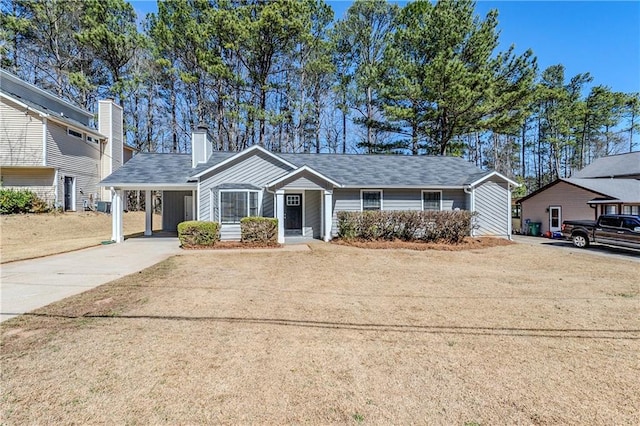 ranch-style house with a carport, concrete driveway, and a chimney