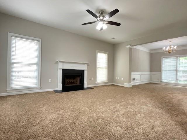 690 Kimball Parc Way, Alpharetta, GA 30022 - unfurnished living room with carpet floors, a fireplace with flush hearth, a chandelier, a ceiling fan, and crown molding