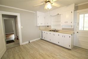 kitchen featuring light countertops, a sink, and white cabinetry