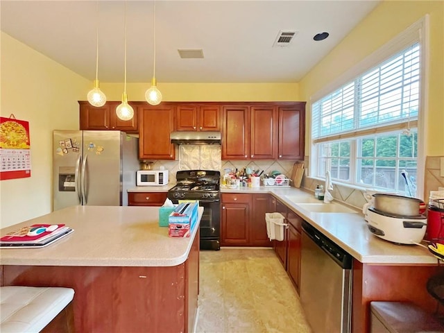 kitchen featuring stainless steel appliances, under cabinet range hood, a sink, light countertops, and tasteful backsplash