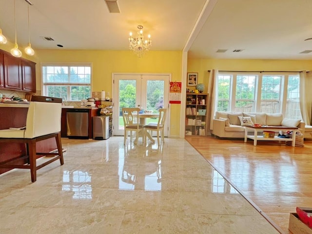 dining space with french doors and a chandelier