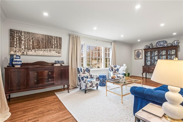living area featuring ornamental molding, wood finished floors, and recessed lighting