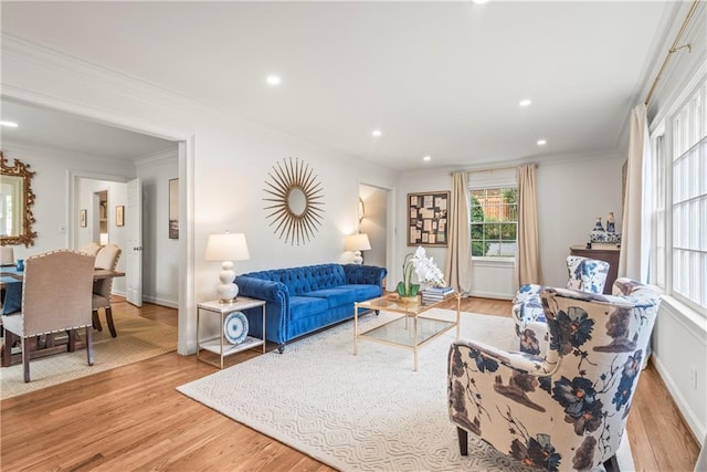 living room with light wood-style flooring, ornamental molding, baseboards, and recessed lighting