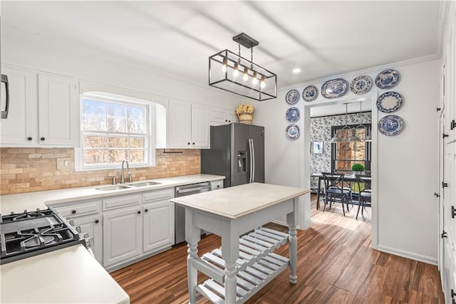 kitchen featuring ornamental molding, a sink, stainless steel appliances, and a wealth of natural light