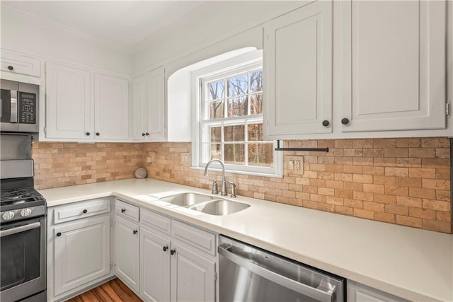 kitchen featuring white cabinetry, a sink, stainless steel appliances, and tasteful backsplash