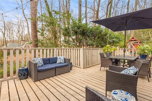 deck with a playground, an outdoor living space, and outdoor dining space