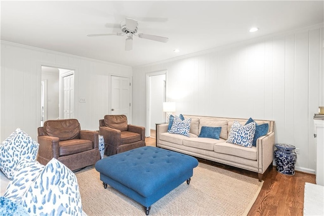 living area featuring crown molding, wood finished floors, and a ceiling fan