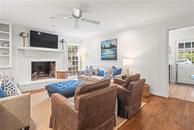 living room featuring ornamental molding, wood finished floors, ceiling fan, and plenty of natural light