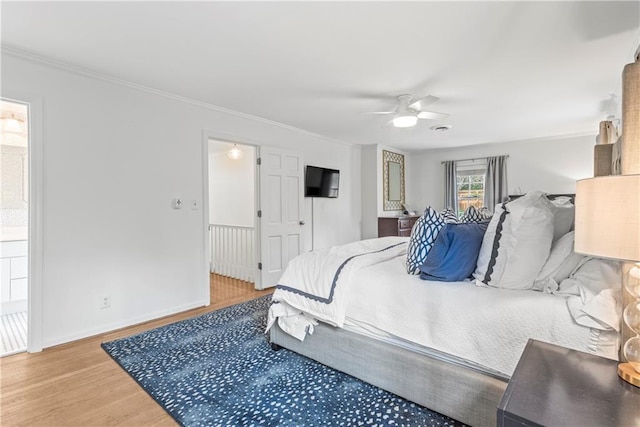 bedroom with a ceiling fan, light wood-style flooring, crown molding, and baseboards