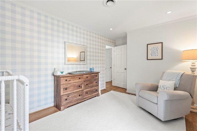 sitting room with wallpapered walls, recessed lighting, and crown molding