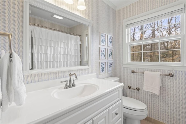 bathroom featuring ornamental molding, wallpapered walls, toilet, and vanity