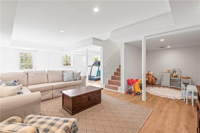 living room featuring recessed lighting, visible vents, stairs, and light wood-type flooring