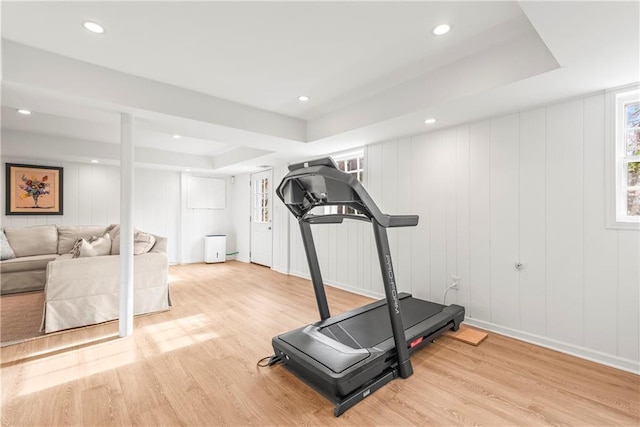 workout room with wood finished floors, recessed lighting, and a raised ceiling