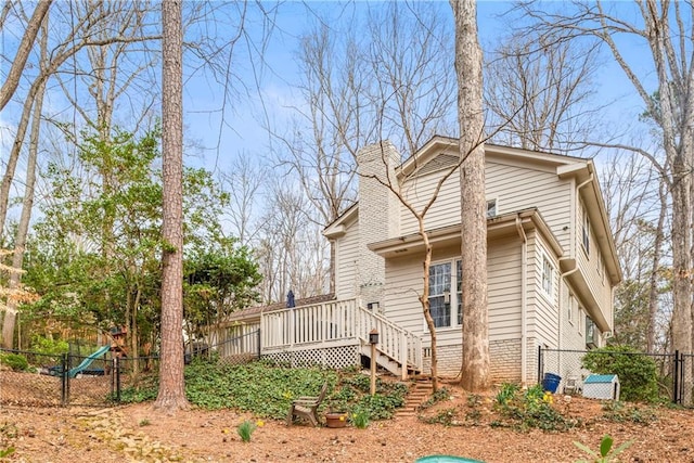 view of side of home with a fenced backyard, stairs, a chimney, and a deck