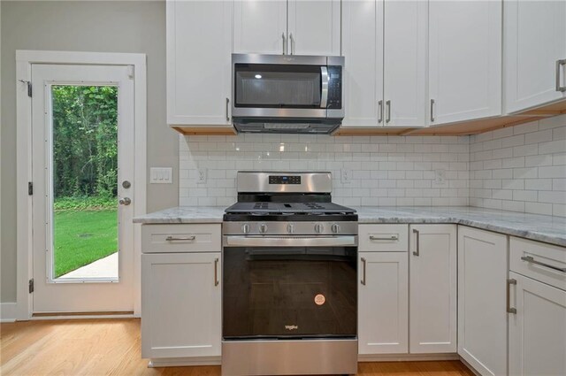 1857 Derrill Dr, Decatur, GA 30032 - kitchen with decorative backsplash, light stone countertops, stainless steel appliances, and light wood-type flooring