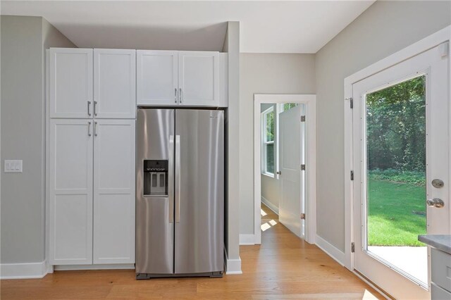 1857 Derrill Dr, Decatur, GA 30032 - kitchen with light countertops, stainless steel fridge with ice dispenser, white cabinetry, light wood-style flooring, and baseboards