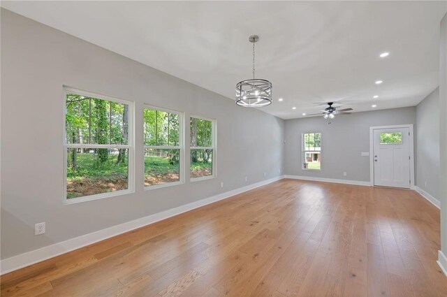 1857 Derrill Dr, Decatur, GA 30032 - unfurnished living room with baseboards, recessed lighting, light wood-style flooring, and ceiling fan with notable chandelier