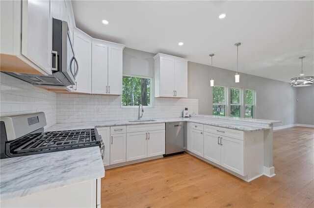 1857 Derrill Dr, Decatur, GA 30032 - kitchen with a sink, appliances with stainless steel finishes, a peninsula, white cabinets, and light wood-style floors