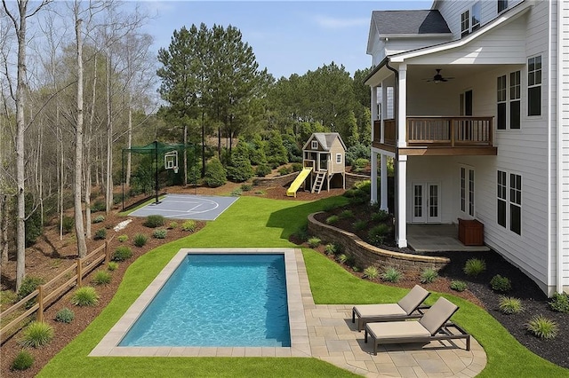 view of swimming pool featuring ceiling fan, a yard, a patio area, and a fenced in pool