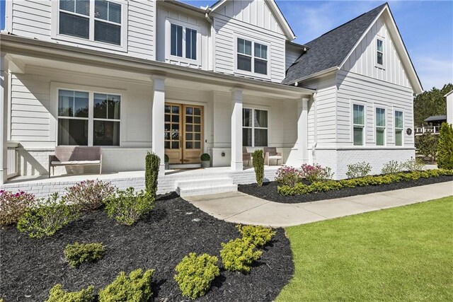 exterior space with covered porch, brick siding, and board and batten siding