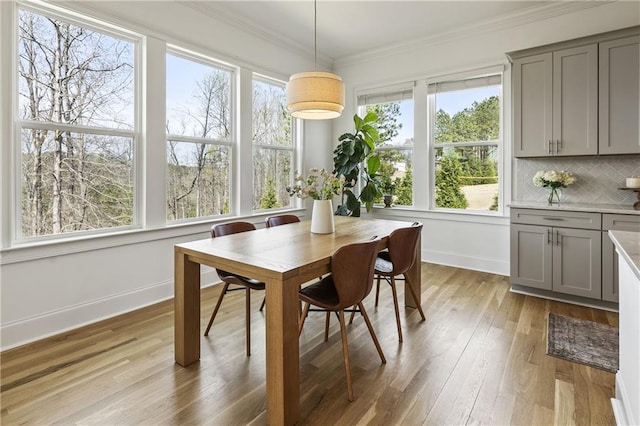 dining area with crown molding, baseboards, and wood finished floors