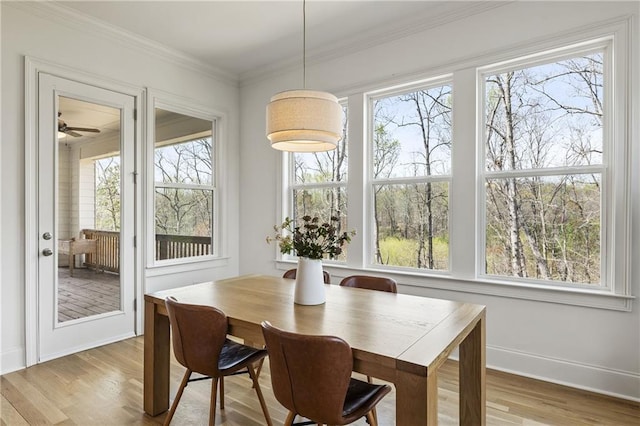 dining area with baseboards, ornamental molding, and wood finished floors