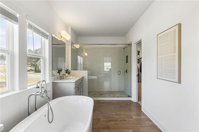 bathroom with a soaking tub, vanity, a shower stall, and a healthy amount of sunlight