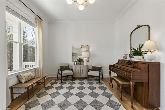 living area with baseboards, ornamental molding, and wood finished floors