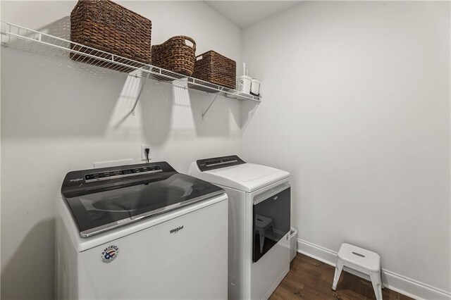washroom featuring baseboards, dark wood-style flooring, washing machine and dryer, and laundry area