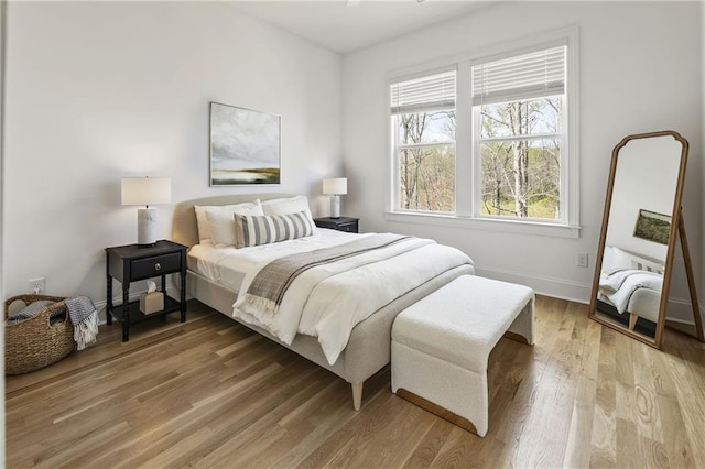 bedroom with light wood-type flooring and baseboards