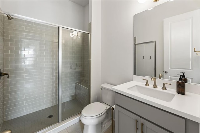 full bathroom featuring a stall shower, vanity, and toilet