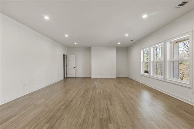 unfurnished room with light wood finished floors, baseboards, visible vents, and recessed lighting