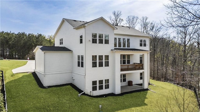 back of property with a balcony, a yard, and a patio