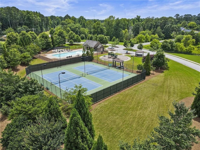 view of sport court featuring a yard, fence, and a community pool