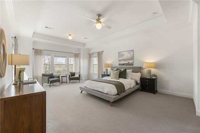 bedroom with light colored carpet, visible vents, baseboards, and a raised ceiling