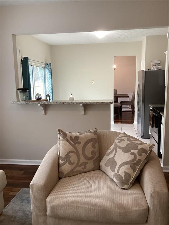 living area featuring baseboards and light wood finished floors