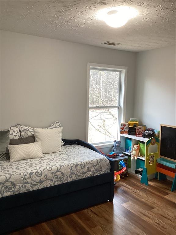 bedroom featuring a textured ceiling and wood finished floors