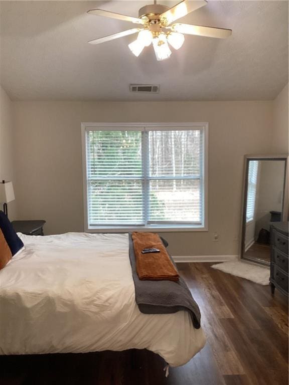 bedroom featuring visible vents, lofted ceiling, ceiling fan, and wood finished floors