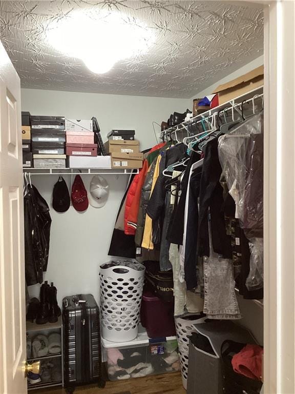 walk in closet with wood finished floors