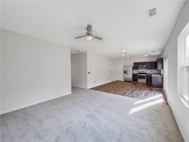 unfurnished living room with ceiling fan, wood-type flooring, and sink