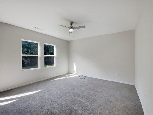 carpeted spare room with ceiling fan