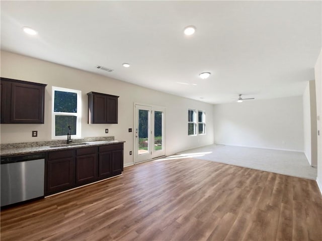 kitchen with dishwasher, light stone countertops, sink, wood-type flooring, and ceiling fan