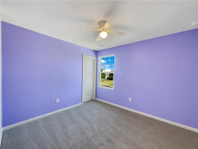 carpeted spare room featuring ceiling fan