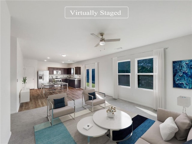 living room with light wood-type flooring and ceiling fan